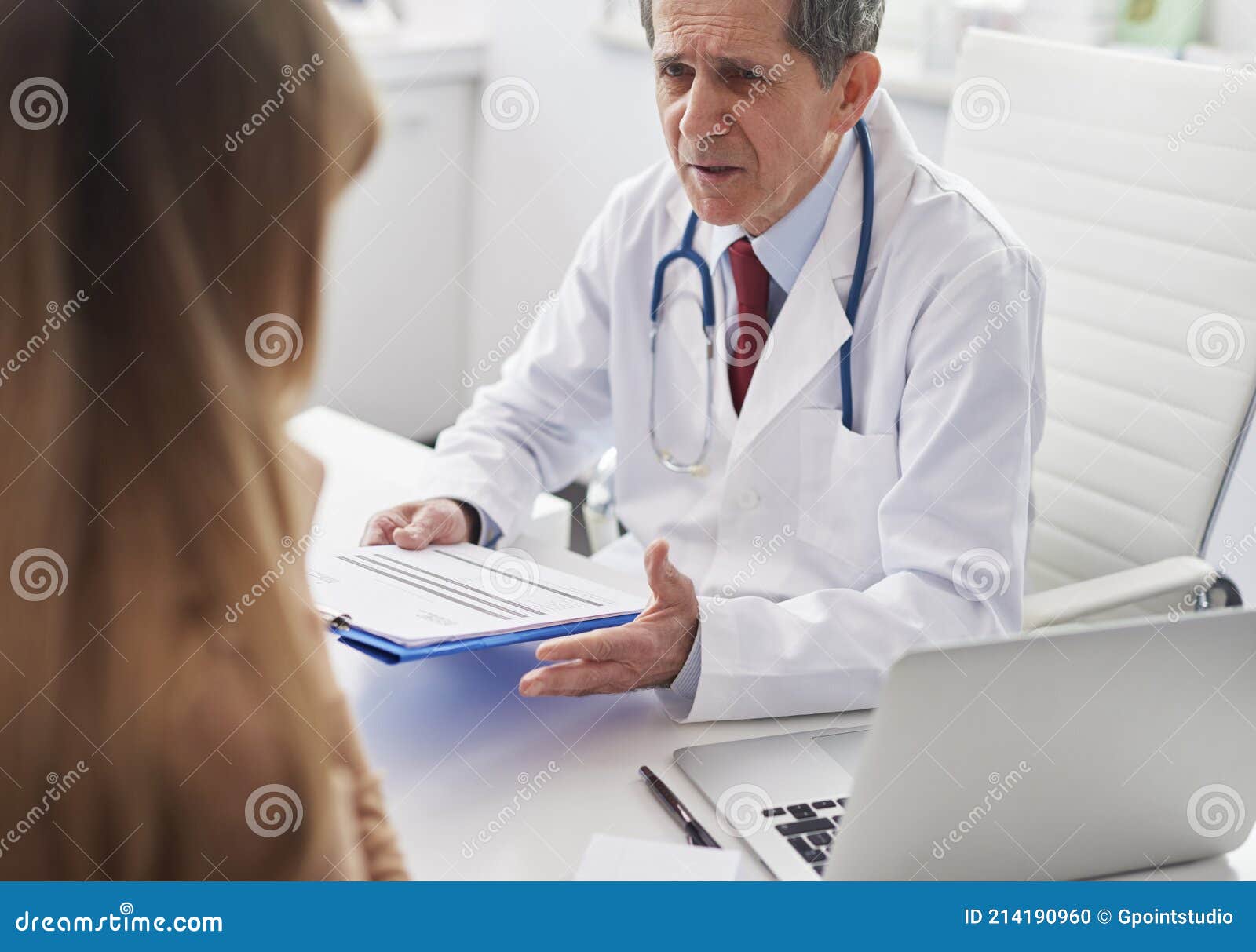 senior doctor talking to woman in doctorÃ¢â¬â¢s office